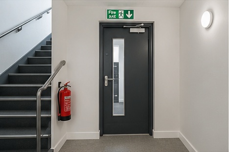Black fire door beside a protected stair enclosure